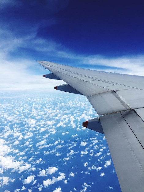 Airplane wing flying over clouds