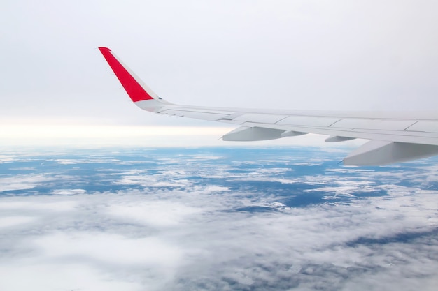 Airplane wing flying above the clouds