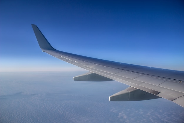 Airplane wing in the sky. View from a great height.