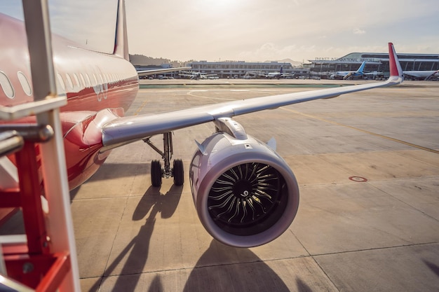 Airplane wing and turbine on airport background