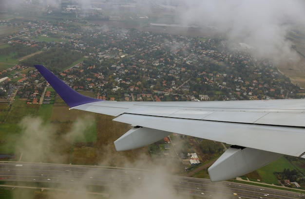 飛行機から空、雲、地球までの飛行の高さからの飛行機の翼の眺め。