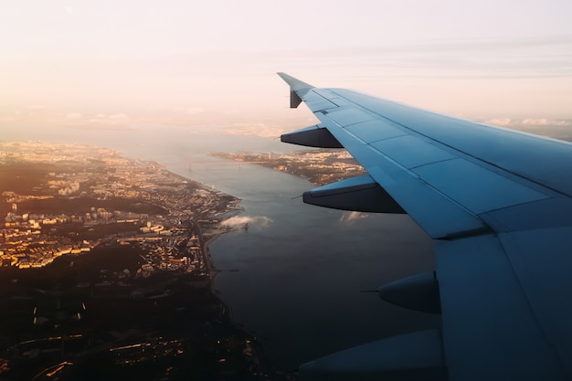 Airplane wing view from window seat above Vasco de Gama bridge i