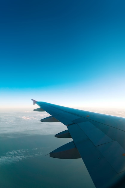 Airplane wing with blue sky and cloud