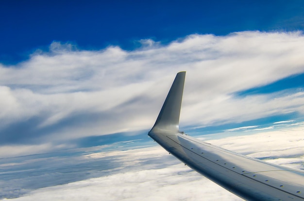 Airplane wing with clouds background and copyspace