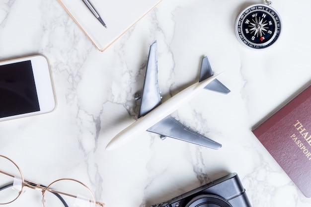 Airplane with travel accessories on marble surface