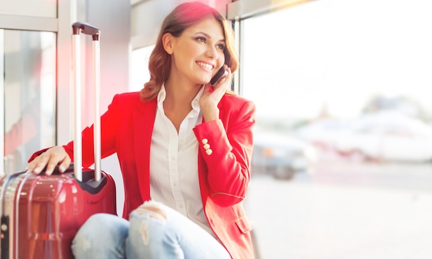 ターミナルで待っているゲートでスマートフォンの空港ビジネス女性。