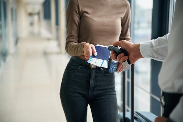 Foto un impiegato dell'aeroporto sta controllando i biglietti di una turista in primo piano