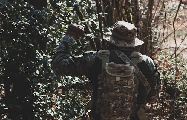 Airsoft military game player in camouflage uniform with armed assault rifle