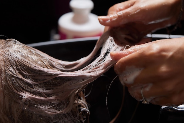 Airtouch Hair stylist makes bouffant using comb on thin strands Shatush technique for hair lightening