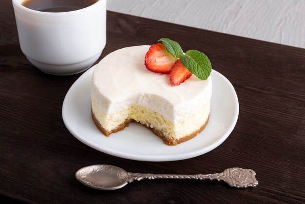 Airy cheese dessert, teaspoon and cup of coffee.