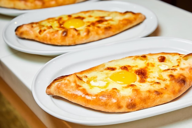 Ajarian traditional flatbread khachapuri or hachapuri with cheese egg and butter on a plate