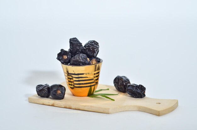 Photo ajwa dates or kurma ajwa are one of the special fruits of ramadan isolated on white background