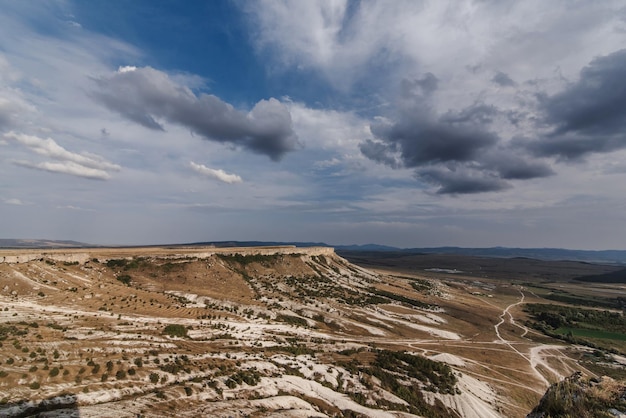 AkKaya or White Rock in Crimea is a rocky limestone plateau in summer under a cloudy sky