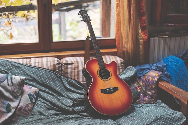 Akoestische gitaar die op een bank rust nadat hij is bespeeld