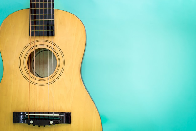 Akoestische gitaar die tegen een groene achtergrond rust