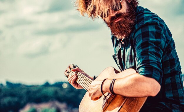 Akoestische gitaren Acoustic gitaren Mannelijke muzikant die gitaar speelt