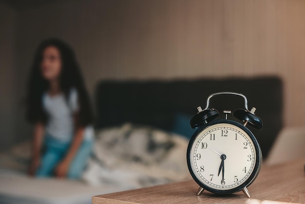 alarm clock on the background of a girl waking up