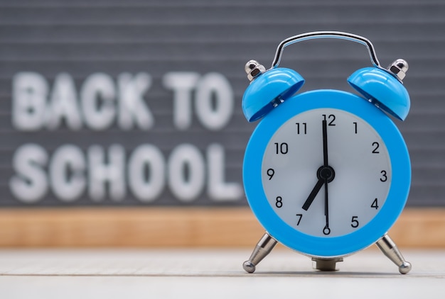 alarm clock on the background of a wooden plaque