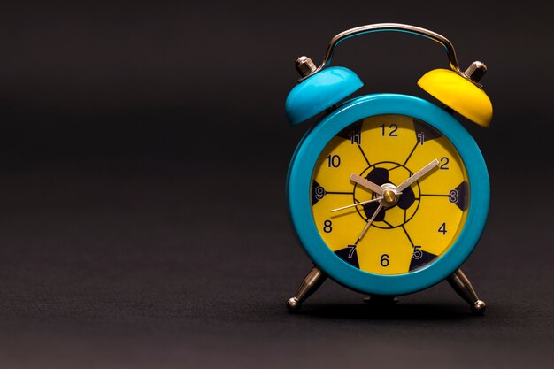 Photo the alarm clock on black background. colored