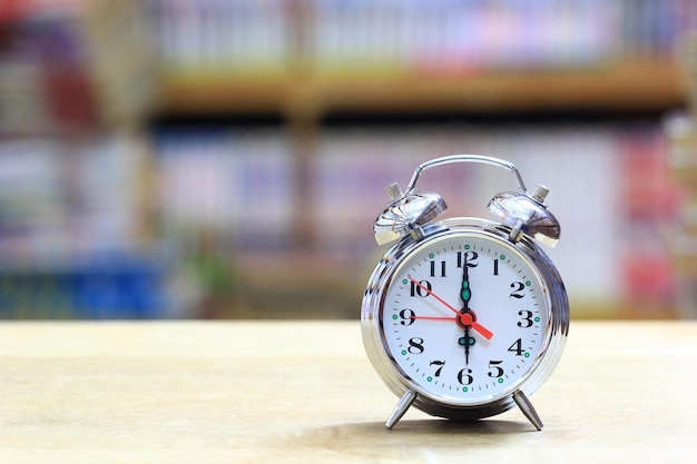 Photo alarm clock on bookshelf in the library room background