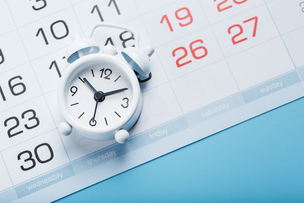 Alarm clock and calendar on a blue background