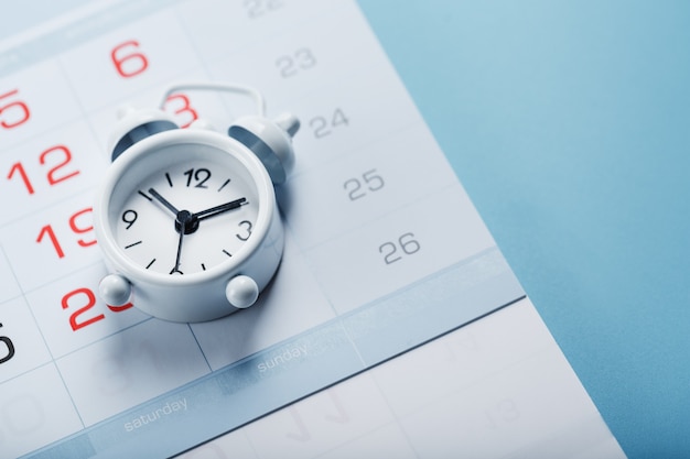 Alarm clock and calendar on a blue background.