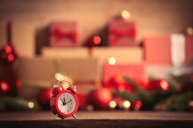 Alarm clock and christmas gift on background