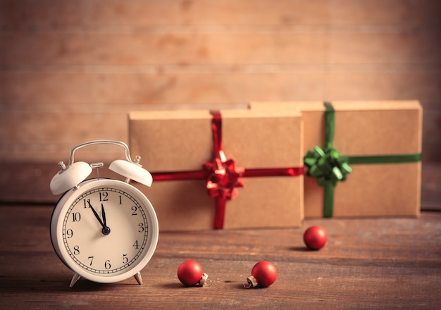 Alarm clock and christmas gifts on background