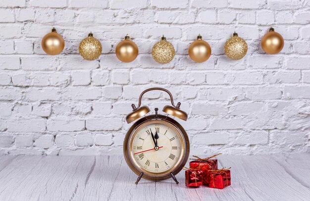 Alarm clock Christmas tree gifts Christmas toys on the background of a brick wall