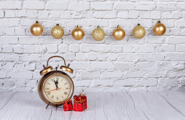 Alarm clock Christmas tree gifts Christmas toys on the background of a brick wall