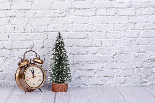 Alarm clock Christmas tree gifts Christmas toys on the background of a brick wall