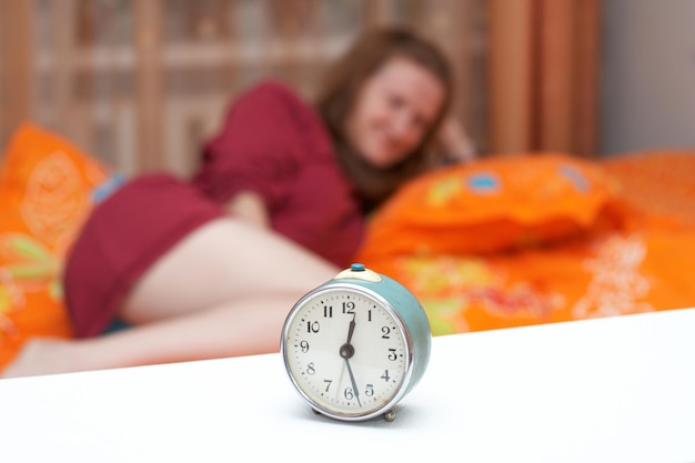 Alarm clock disturbing a sleeping woman that is defocused