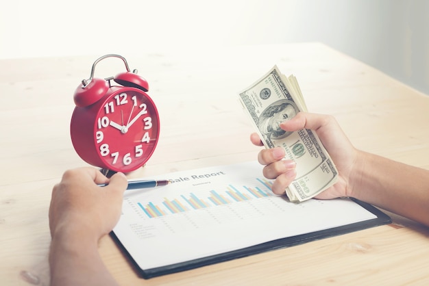 Alarm clock, hand  money grip, graph on his desk