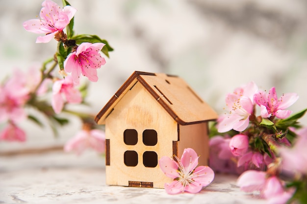 Alarm clock, house, flowering branch in the spring.