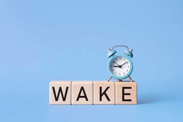 Alarm clock and the inscription wake up on a blue background.