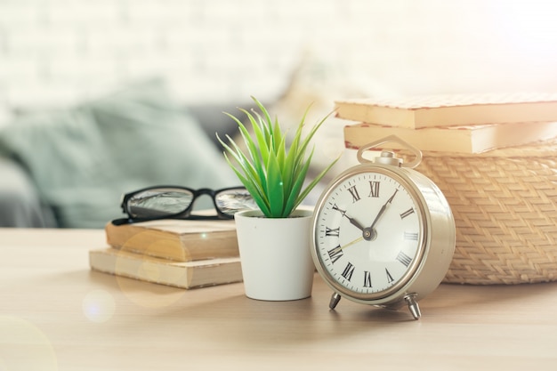 Photo alarm clock and office stationery objects close up on wooden table