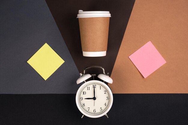 Alarm clock paper cup and colored blank paper stickers top view