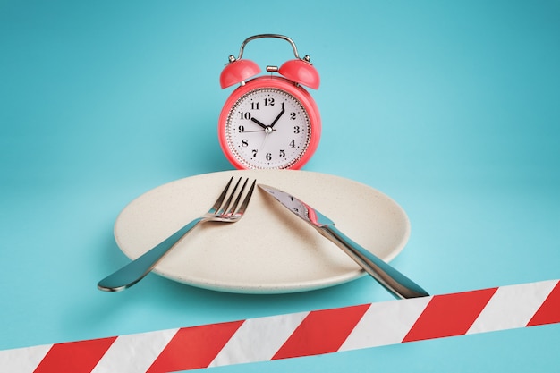 Photo alarm clock, plate with cutlery and barrier tape.