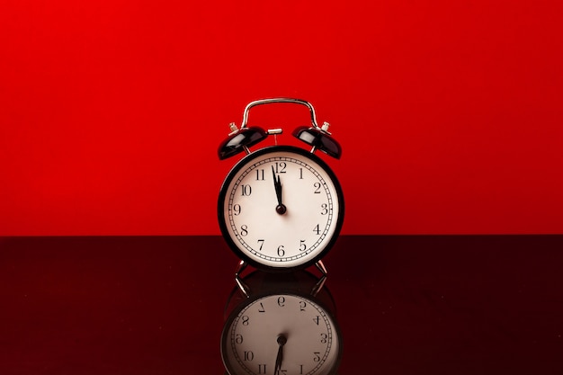 Alarm clock on red background front view