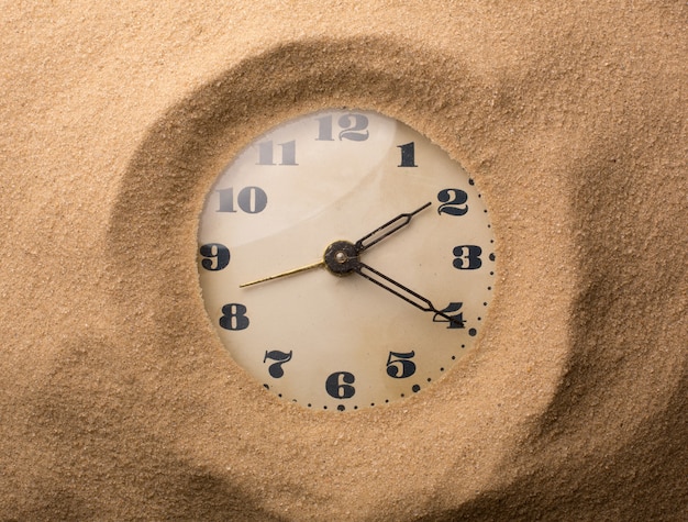 Alarm clock in sand