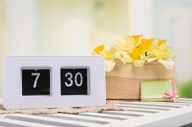 Alarm clock on table on light background