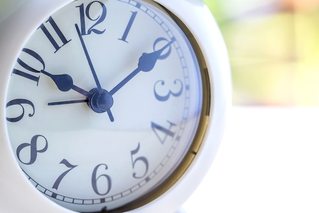 alarm clock on table with green background.