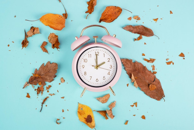 Alarm clock with autumn foliage end of daylight saving time in fall winter time changeover