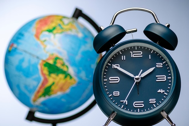 Alarm clock with bells in front of a world globe