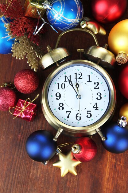 나무 배경에 크리스마스 장식이 있는 알람 시계