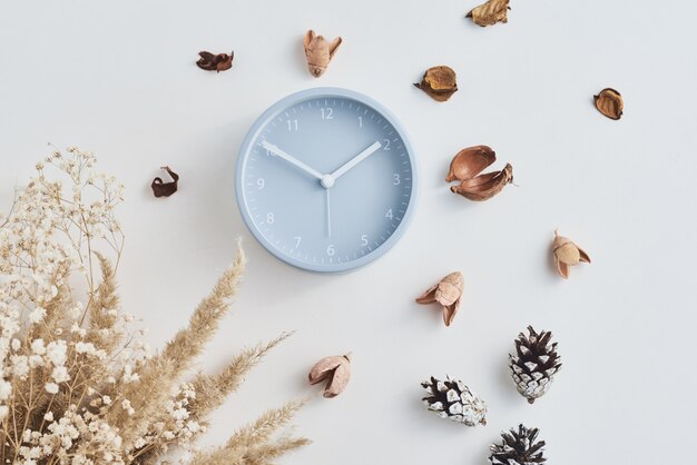 Alarm clock with decorations on white, top view. Minimal flat lay style