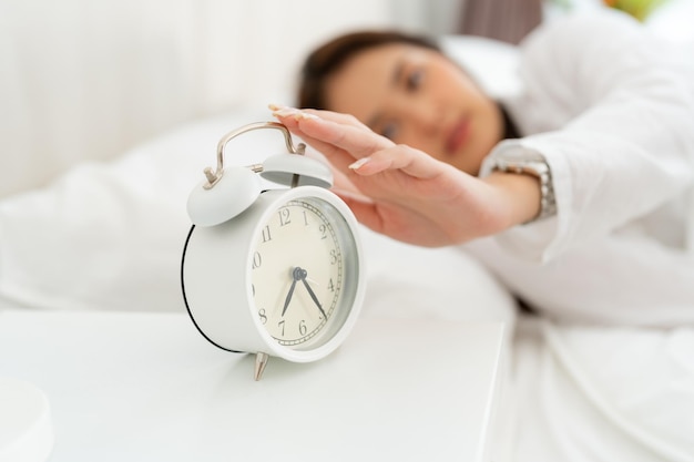 Alarm clock with good day against background happy young woman