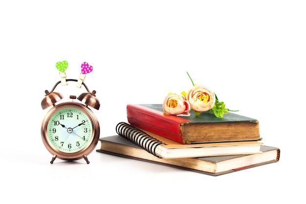 alarm clock with love heart sign and old book on isolate