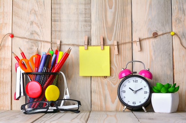 Alarm clock with sticky note on wooden table