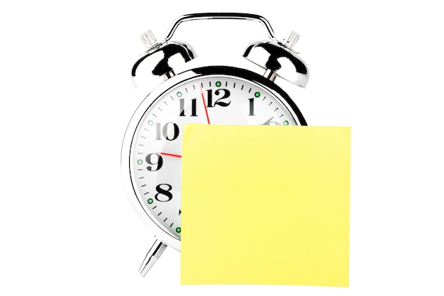Alarm Clock with yellow blank note paper on the white